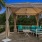 cabana with couch and table beside pond